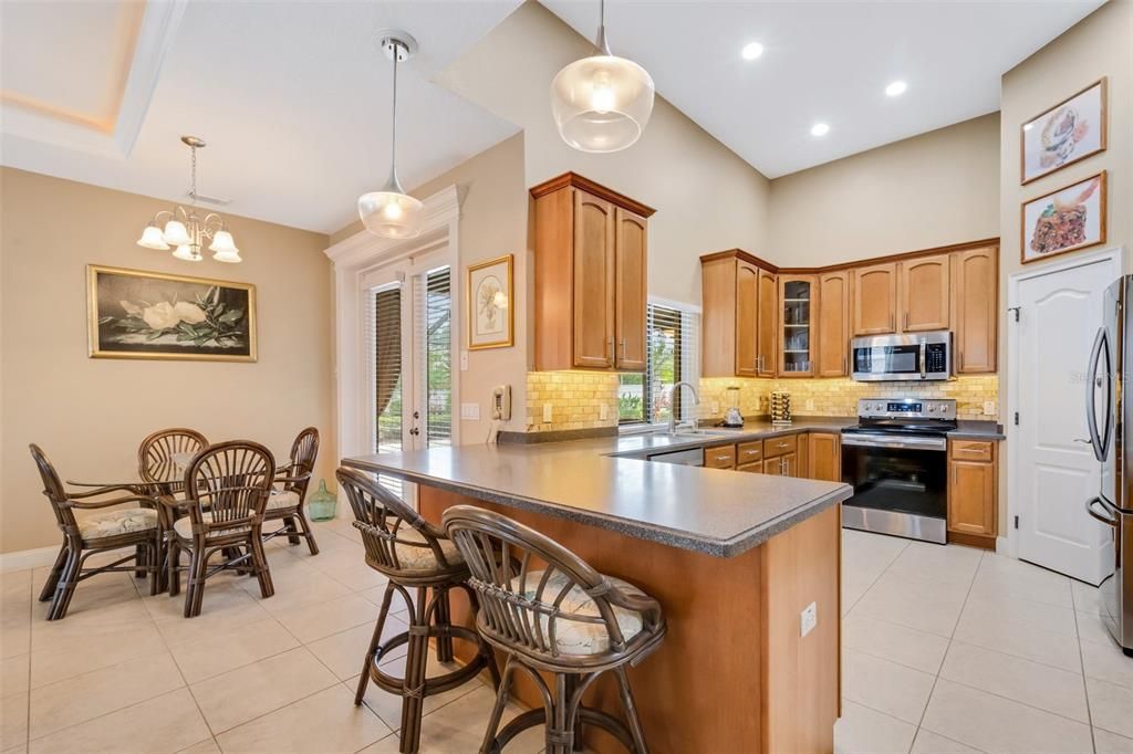The adjacent kitchen features great lighting, tall ceilings, stainless steel appliances and a closet pantry.