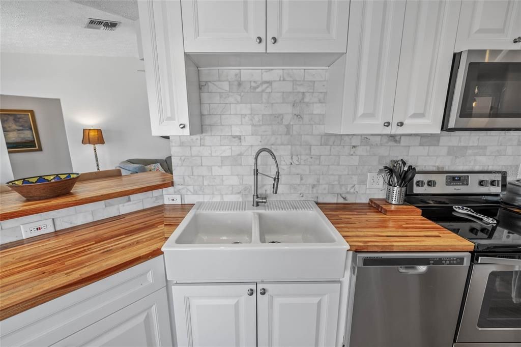 Farmers sink with white cabinets.