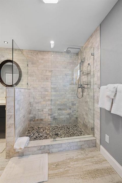 Primary suite bathroom with tile flooring, walls and accents.