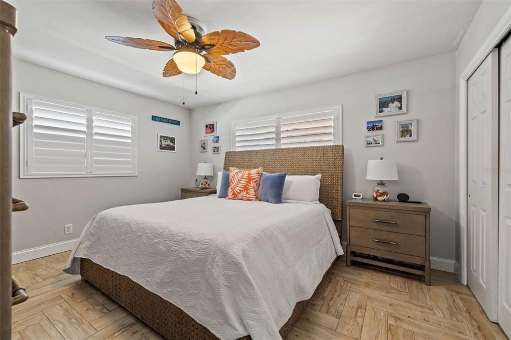 Master bedroom with wood-look tile, neutral paint colors and two closets