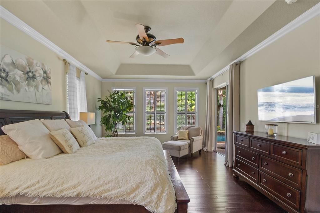 The master bedroom is truly a retreat, located on the opposite side of the home away from guest rooms. It features bamboo wood flooring, tray ceiling, crown molding, ensuite master bath and covered lanai access.