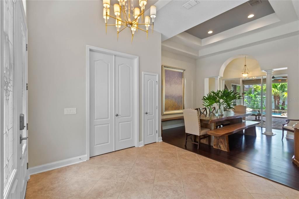 The dining area features triple sliding doors leading onto the covered lanai and pool deck.