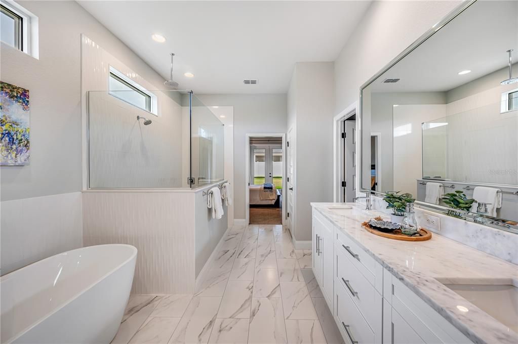 Ensuite bathroom with dual sink vanity, walk-in shower and soaker tub