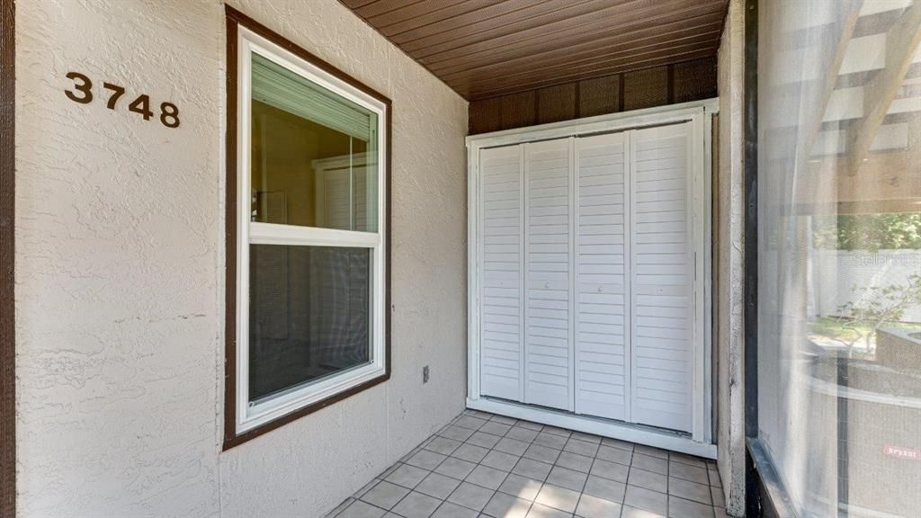 Screened-in front porch with a laundry/storage closet.