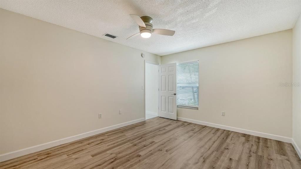 Owners suite featuring laminate flooring, a walk-in closet, and updated ensuite bathroom.