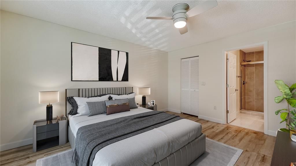 Owners suite featuring laminate flooring, a walk-in closet, and updated ensuite bathroom.