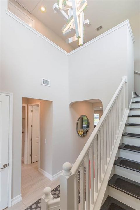 Two story open foyer with custom lighting