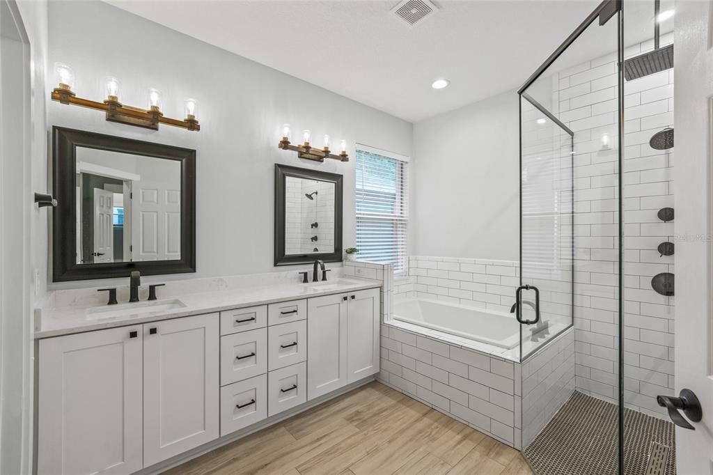 REMODELED master bath with Cambria quartz counters, dovetailed drawers soft close cabinets. Relax in the deep new soaking tub with Moen faucet. Beautiful new shower remodeled with zero entry, frameless shower glass and 12” Moen rainfall shower head