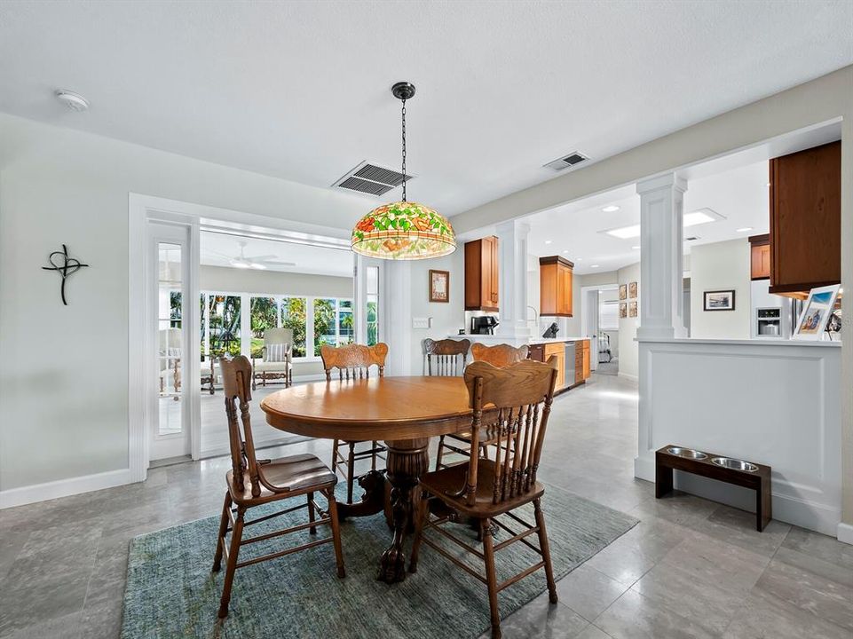 The dining area is open to the kitchen with gorgeous flooring and lush, tropical views
