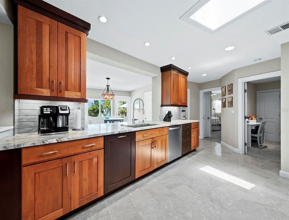 The kitchen features custom wood cabinets and gorgeous countertops and a bar top out to the large bonus room.