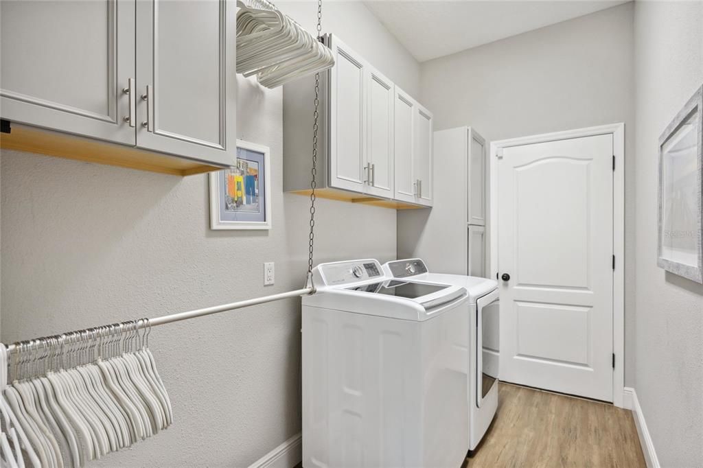 Utility room with built in cabinetry and clothes rack.