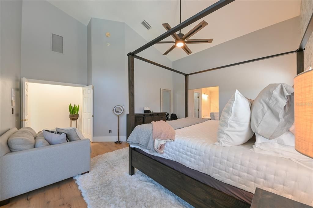 Spacious Master Bedroom with sliders out to the lanai, vaulted ceilings, new flooring and wallpaper.