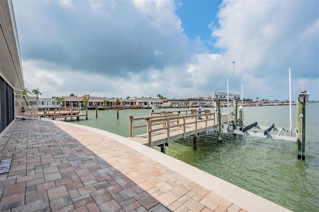 Rear view of oversized patio with pavers leading to the large dock and no neighbor close by