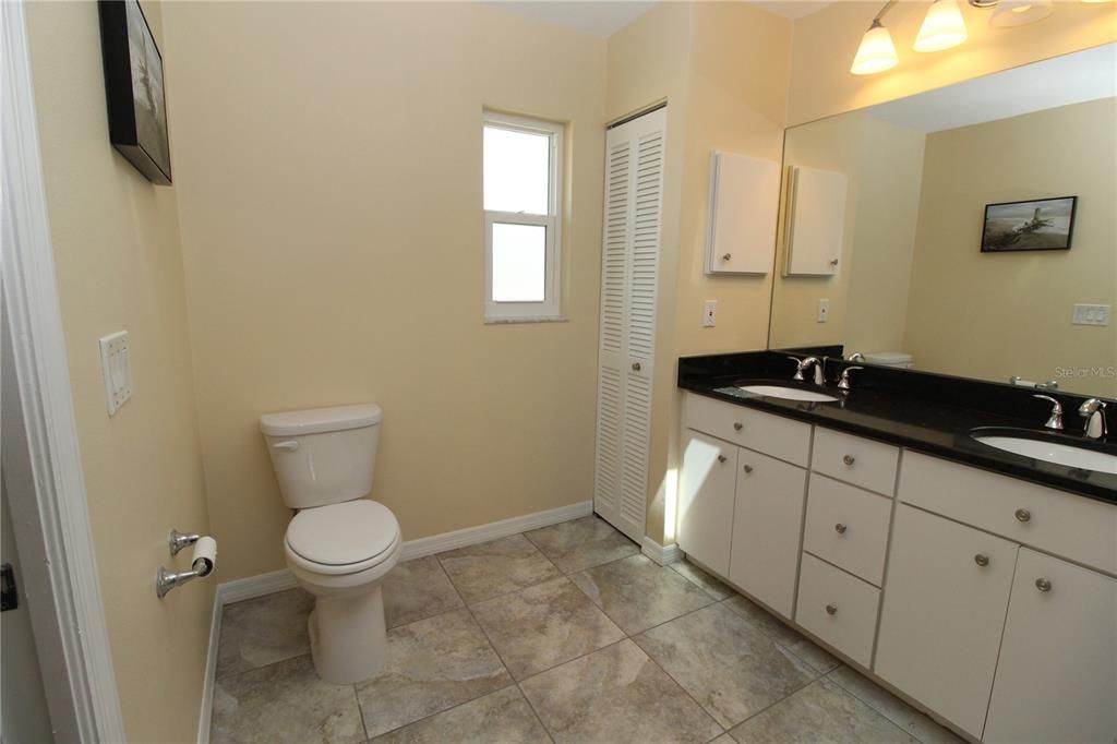 Primary Bathroom with dual sinks and linen closet..