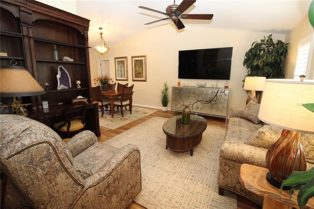 Living room to the right as you walk through front door....Laminate wood flooring....vaulted ceilings....plantation shutters.....ceiling fan....