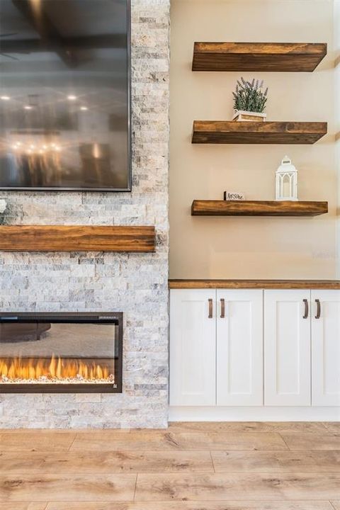 Stone feature wall, floating shelves with electric fireplace