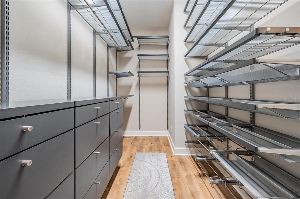 Primary walk in closet with custom shelving