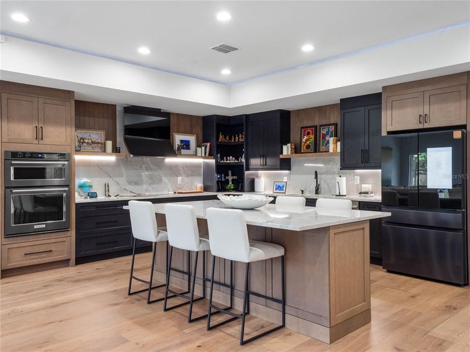 Kiechen features an abundance of storage and counter space with quartz cabinets and modern range hood