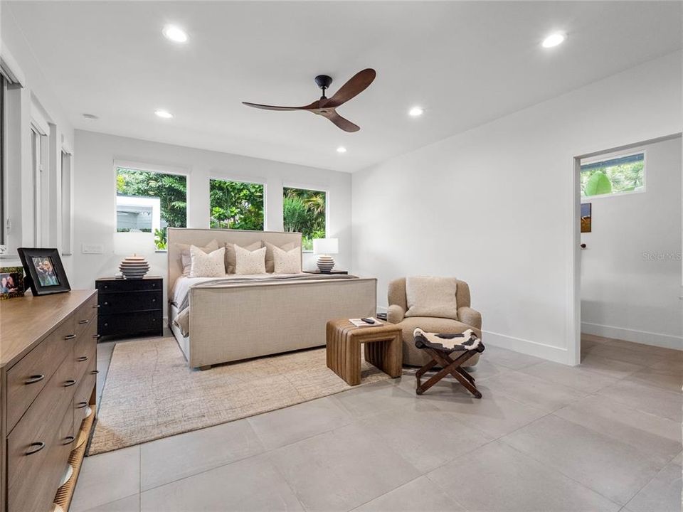 Master suite with large windows and view of the backyard