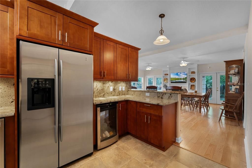 Kitchen with solid wood cabinetry, granite counters, stainless steel appliances and wine fridge