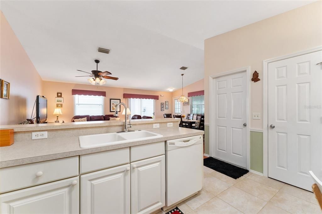 BREAKFAST COUNTER SEPARATES KITCHEN FROM LIVING AREA. KITCHEN HAS PANTRY AND DOOR TO GARAGE.