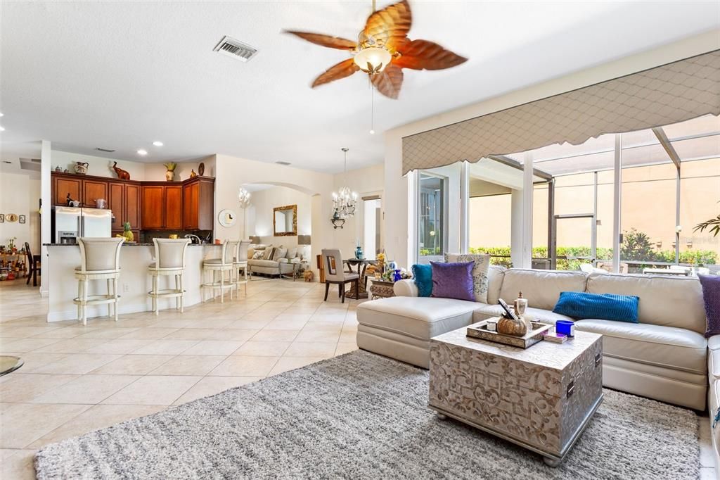 Living room and kitchen with an abundance of windows overlooking cory lake, conservation, and pool