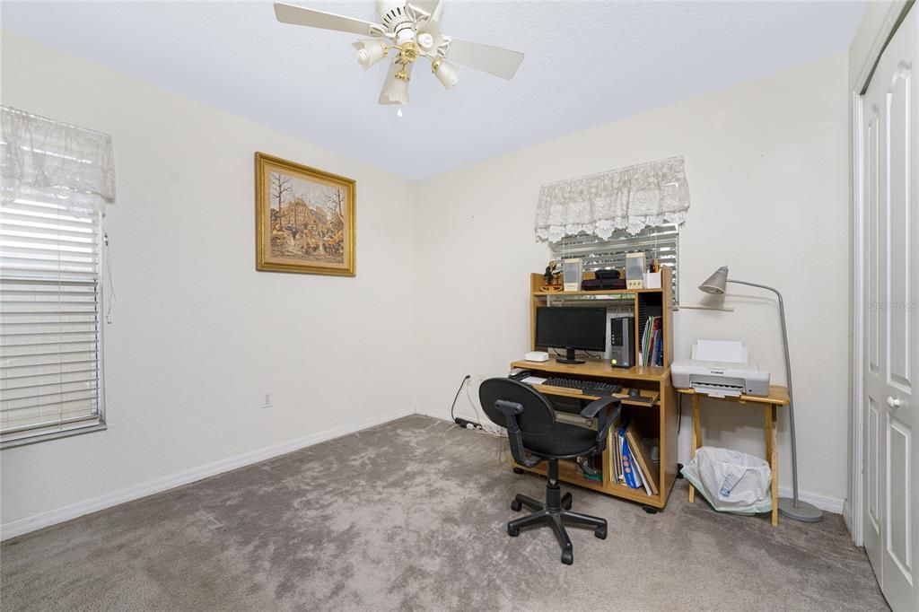 Bedroom #3 has carpeted flooring and a ceiling fan.