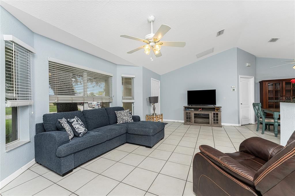 Spacious living room features a cathedral ceiling and ceiling fan.