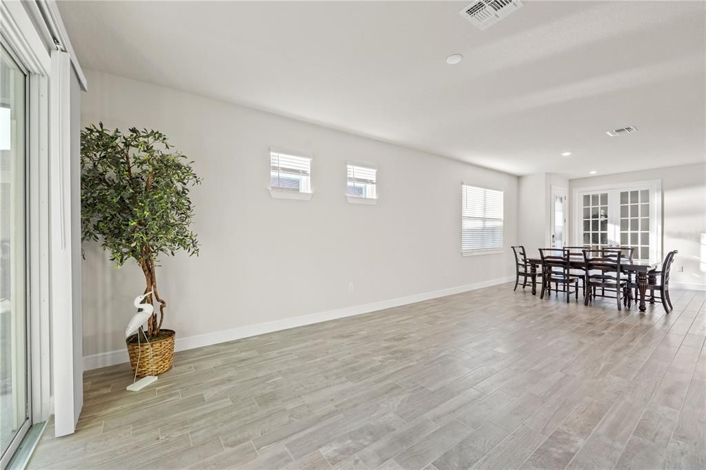 features 6”x24” grey porcelain plank tile with light grey grout flooring throughout the entire home (No carpet), 9'4" ceilings, 8' front door with beautiful glass inlay and enclosed flex room w/glass french doors