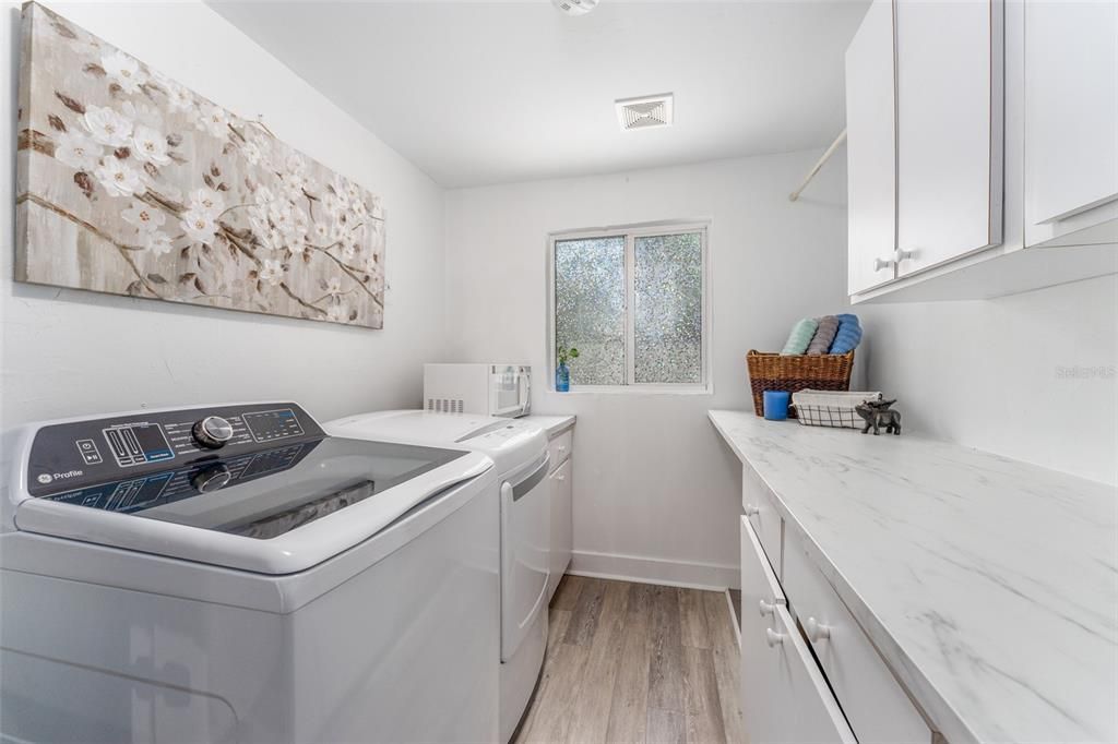 Large Walk-in Laundry Room with Tub Sink and Tons of Cabinets and Counter Space