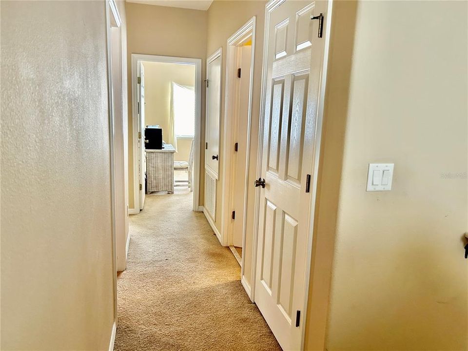 Hallway seen from master bedroom.  Laundry clost is at left.  Secondary bathroom on right.