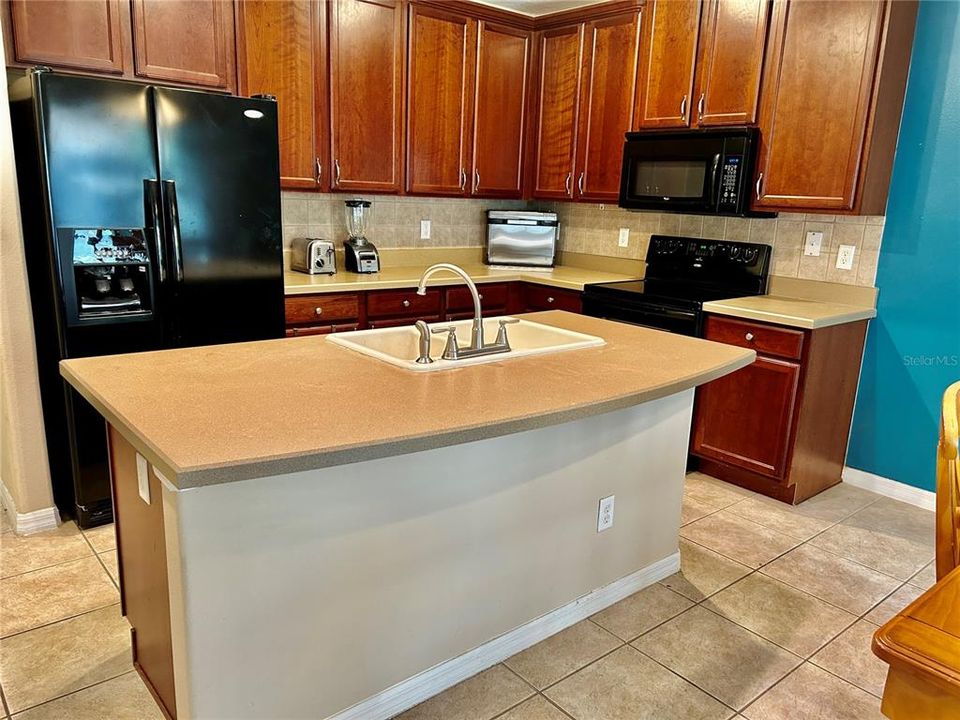 Kitchen with abundant 42" upper cabinets, as seen from great room.  The island offers lots of prep and serving space.