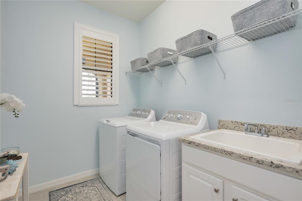 Laundry room with sink and cabinet for storage.