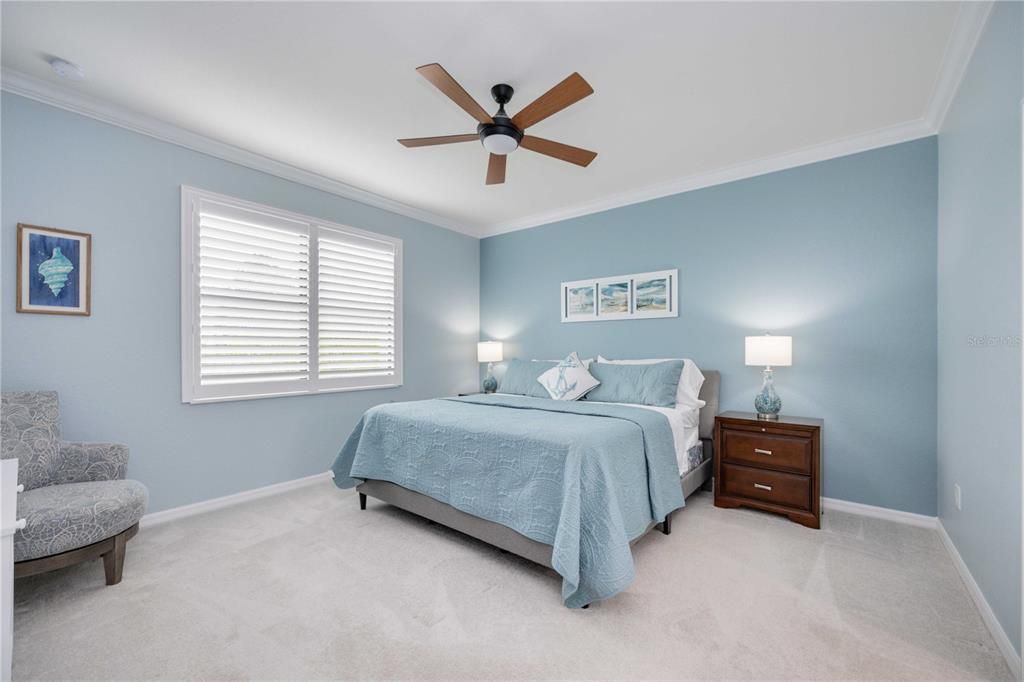 Master bedroom with plantation shutters, crown molding end en suite bathroom