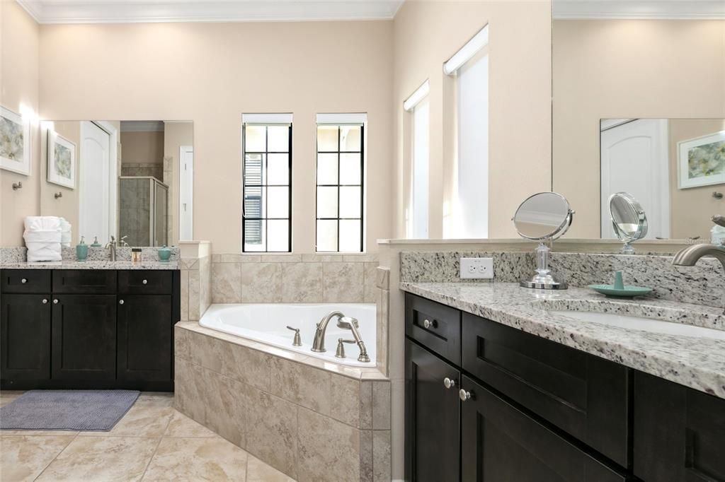 Upper level primary bathroom with soaking tub and separate vanities