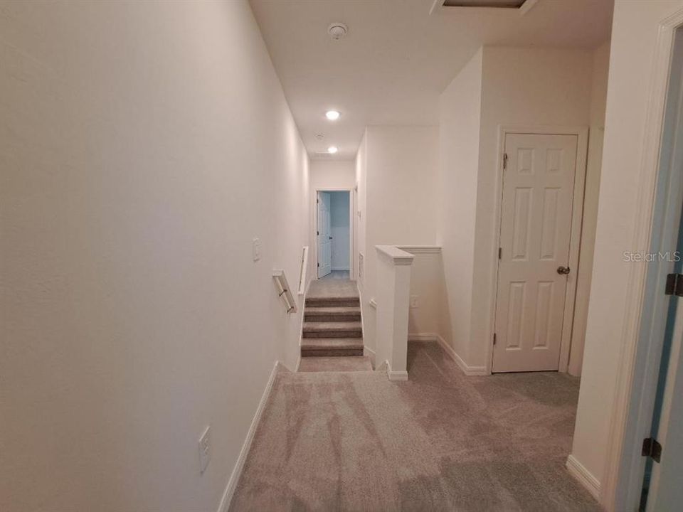 Other - Top of stairway looking to split bedrooms. Primary on one side of stairs, and the guest beds 2&3, guest bath and laundry on the other side.