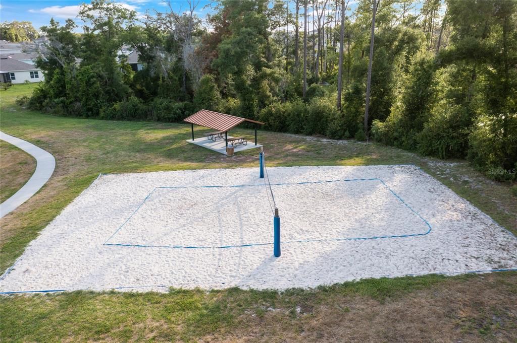 Volleyball court with pavilions for grilling and relaxing.