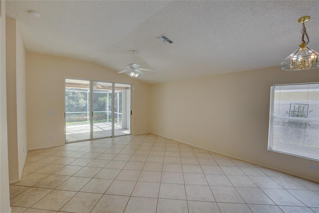 The primary suite has vaulted ceiling, new carpet, a walk-in closet and sliding glass doors to screened-in porch and patio.