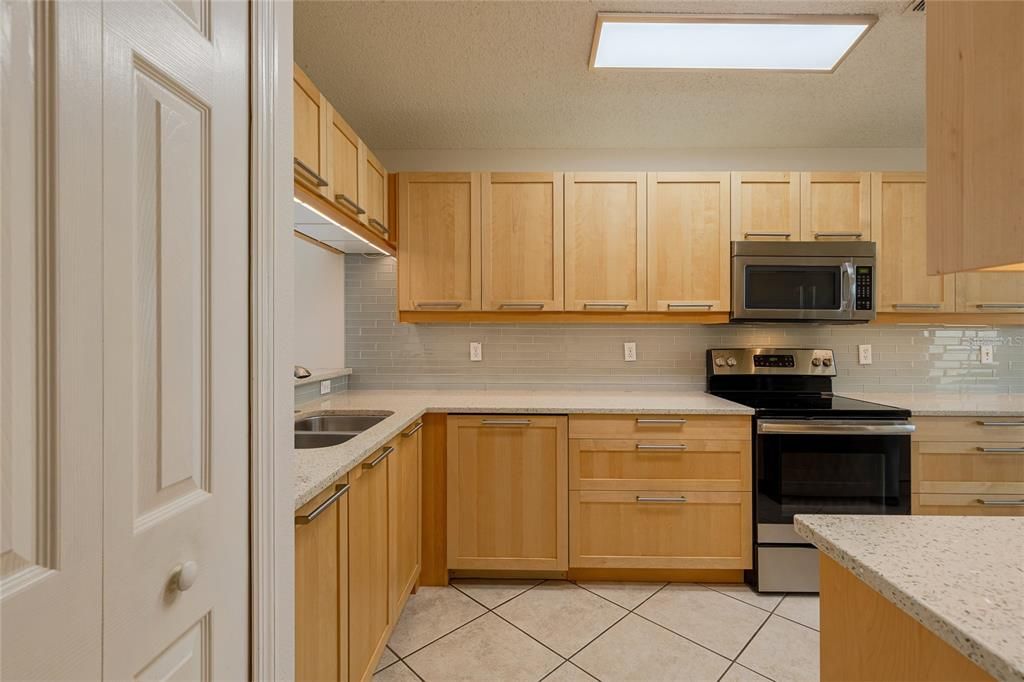 Enjoy cooking with stainless steel appliances and plenty of quartz counterspace and wood cabinetry.