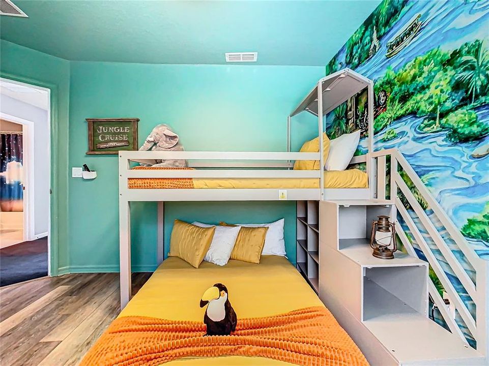 Dive into the jungle right at home! This vibrant, safari-themed bedroom is perfect for your little explorers, offering delightful decor with murals, plush stuffed animals, and bunk beds for adventure-filled nights.