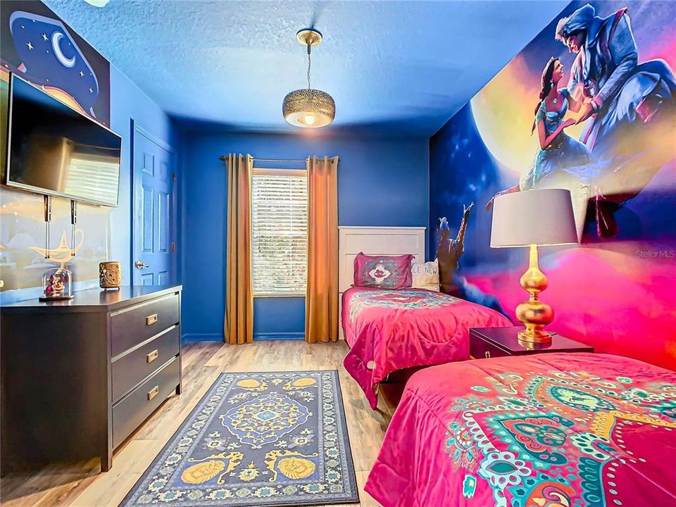 Step into a magical retreat with this Aladin-themed bedroom, perfect for sparking your kids' imagination. Two cozy twin beds adorned with vibrant bedding await in this charming space, complete with an enchanted lamp and whimsical wall mural.