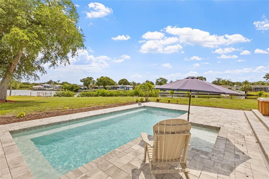 Pool has sun shelf and bench seating in it.