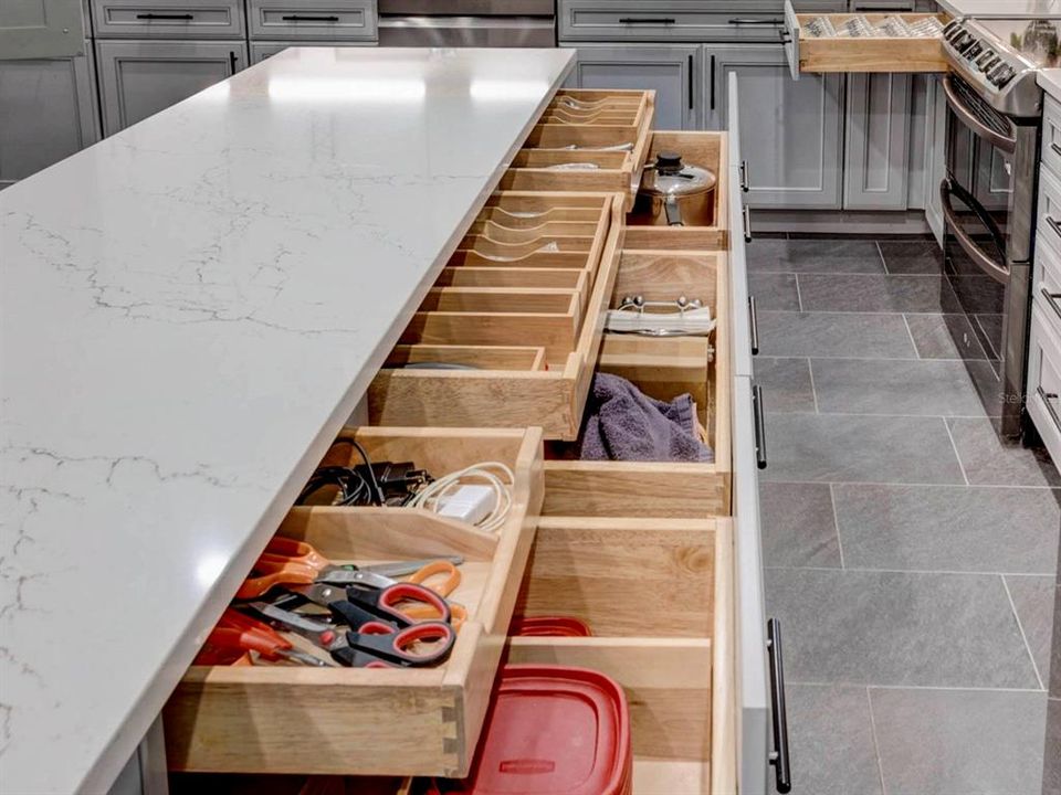 Cabinets with deep drawers and organized top drawer.