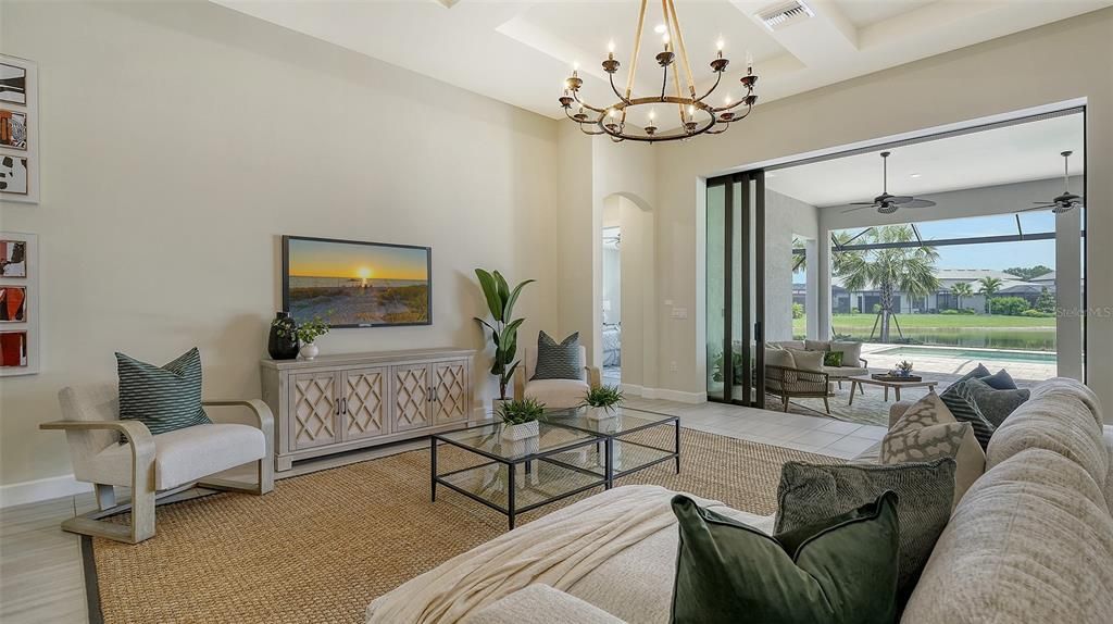 Great room with coffered ceiling and pocket sliders to lanai