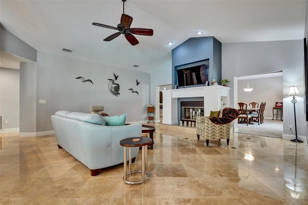 Family room with beautiful fireplace high ceilings open to the kitchen.