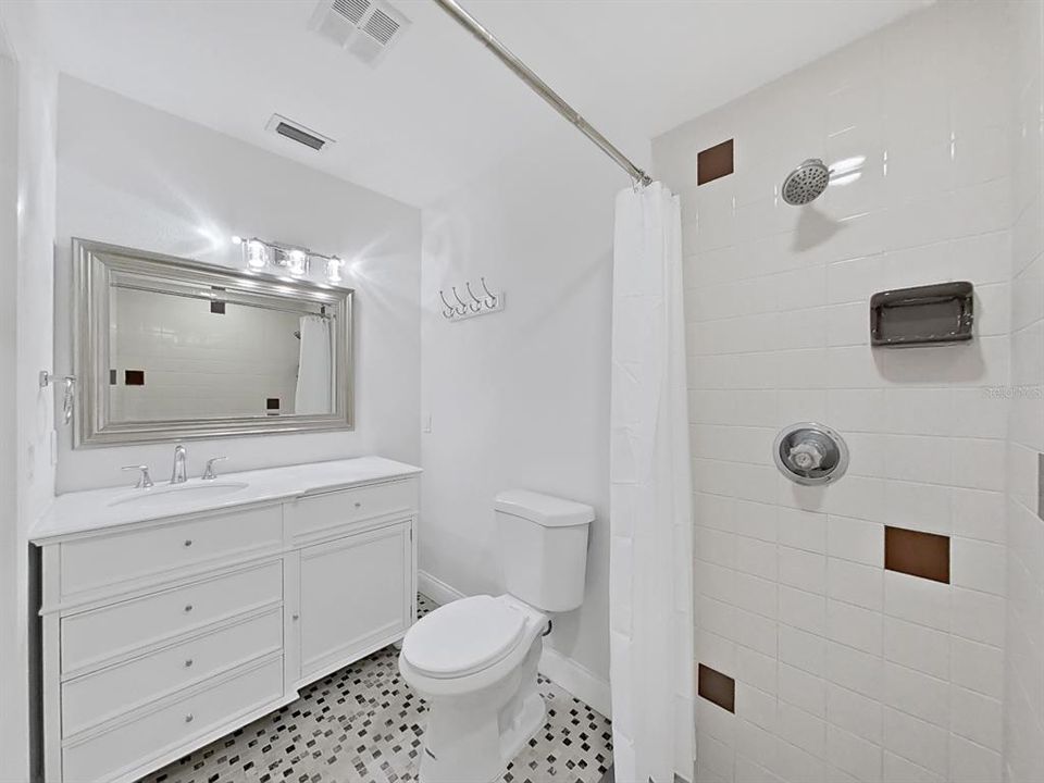 Updated Primary Bathroom with NEW vanity, toilet, lighting, mirror, tile!