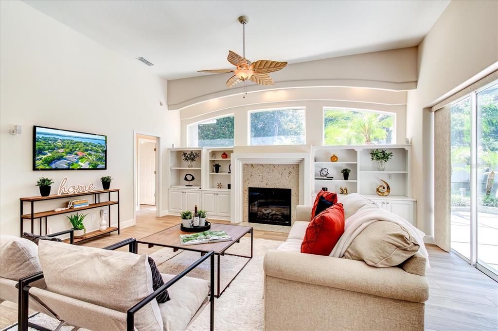 Living room with fireplace and view of pool.