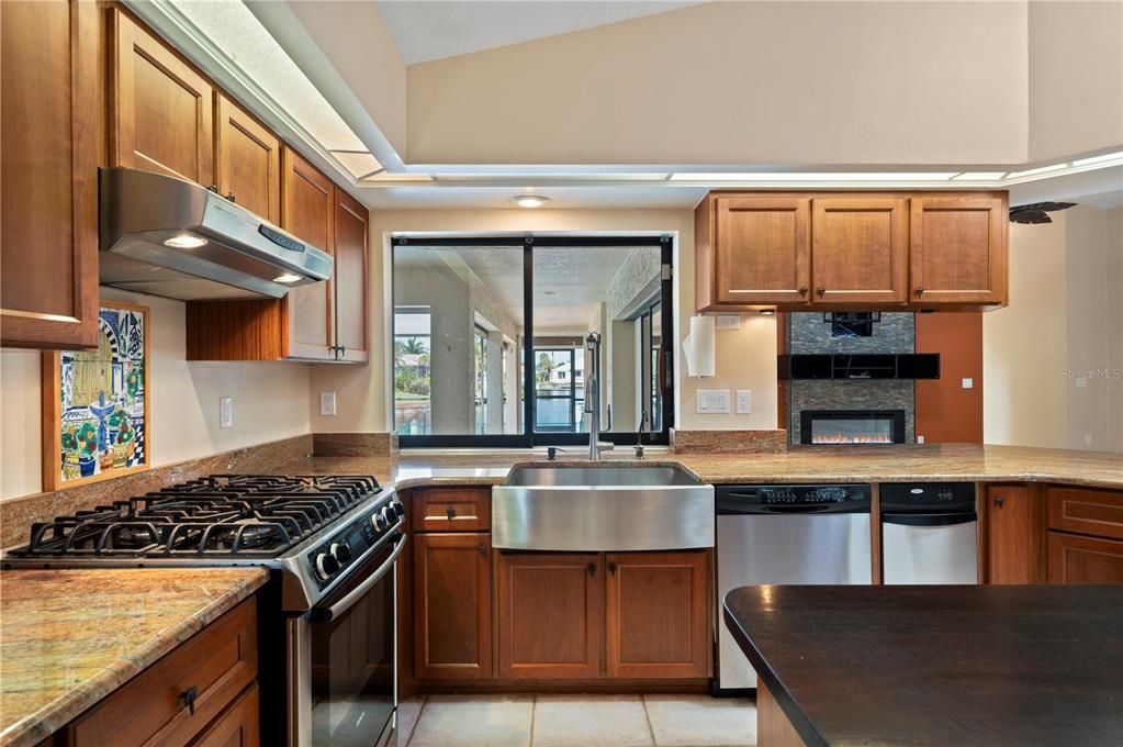 Granite Counters, gas range, and view of the lanai and beyond. Even a view of fireplace from kitchen!