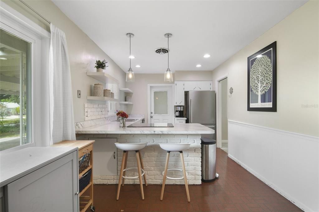 The home chef will appreciate the modern charm the updated kitchen exudes with a neutral color palette, brick accents, pendant lighting and a great mix of storage options.