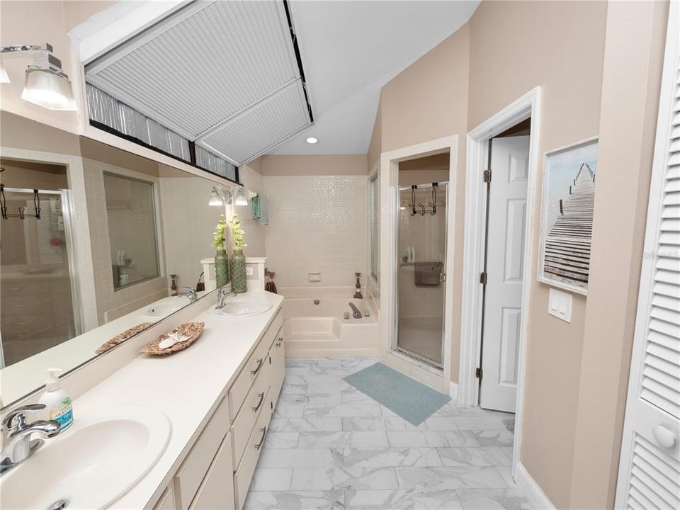 Main bathroom off primary bedroom has double sinks and a huge walk in shower and walk in closet